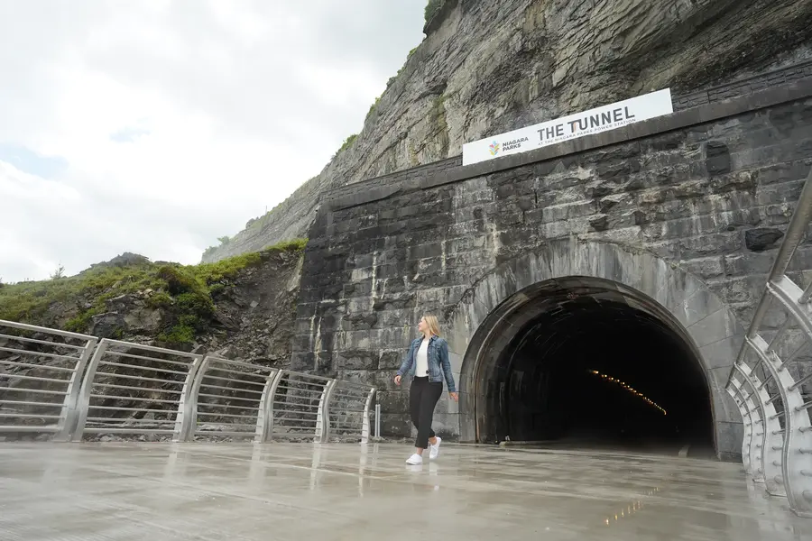 Visitor happily exploring the historic tunnel platform entrance at Niagara Parks Power Station
